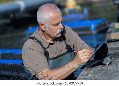 portrait of fish farm worker with clipboard