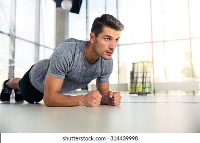 Portrait Of A Fitness Man Doing Planking Exercise In Gym