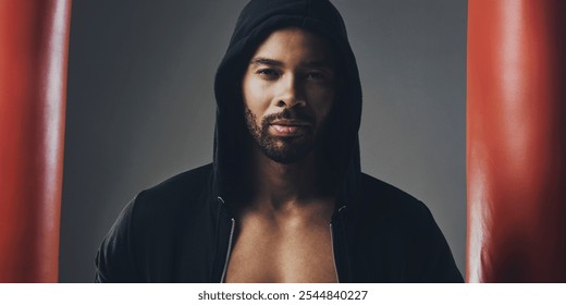 Portrait, fitness and man in hoodie for boxing, exercise or punching bags on gray studio background. Face, sports and African boxer, confident athlete or determined person ready for training in Ghana - Powered by Shutterstock