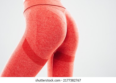 Portrait Of Fitness Woman In Sports Clothing.Sexy Young Female Wearing Pink Sportswear. Beautiful Model With Perfect Tanned Body.Female Posing In Studio On Grey Background. No Face. Unrecognisable 