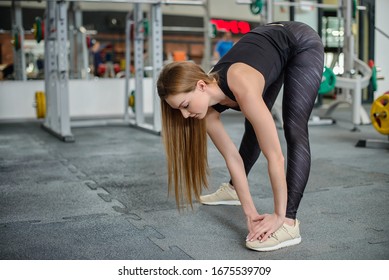 Portrait Of Fitness Woman Stretching At Gym Before Workout. Female Stretch Inner Thigh. Sports Activity, Healthy Lifestyle.