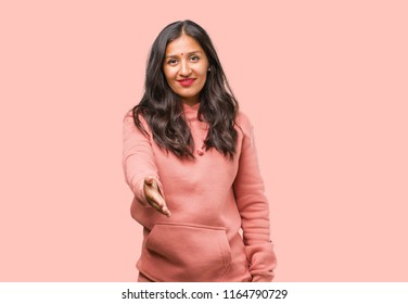 Portrait Of Fitness Young Indian Woman Reaching Out To Greet Someone Or Gesturing To Help, Happy And Excited