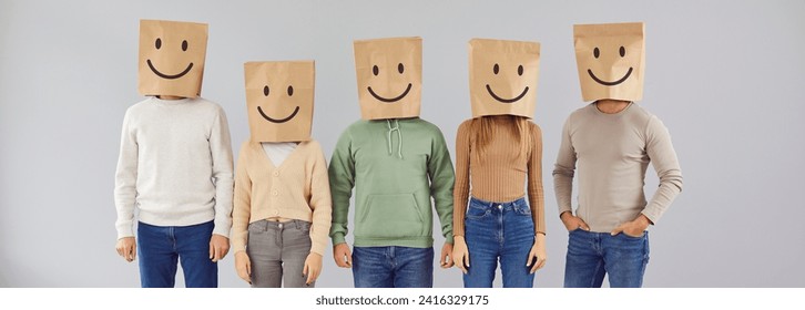 Portrait five casual male and female people with paper shopping package bags over heads with happy smiling emoticon mouth eyes facial expression drawn on them standing on gray color studio background - Powered by Shutterstock