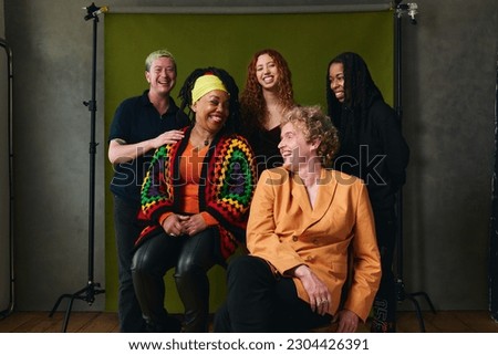 Portrait of five LGBTQIA queer people laughing against studio backdrop gay pride
