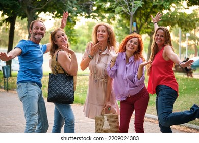 Portrait Of Five Mature Adults Having Fun And Looking At Camera In A Park.