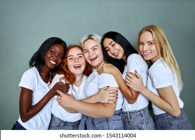 Portrait of five smiling laughing beautiful women in jeans standing together isolated over grey background, hug each other, laugh - Powered by Shutterstock