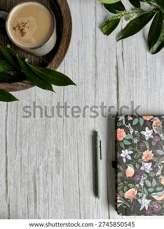 Portrait Flat Lay Of Closed Patterned Notebook With Pen, Coffee Cup And Greenery On Light Wooden Background With Text Space. Academic Planning Concept Suitable For Exam Revision And University Coursework Scheduling. 