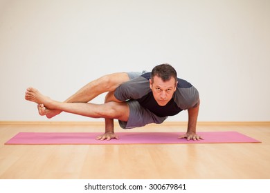 Portrait Of A Flexible Man Practicing A Few Yoga Poses In A Gym