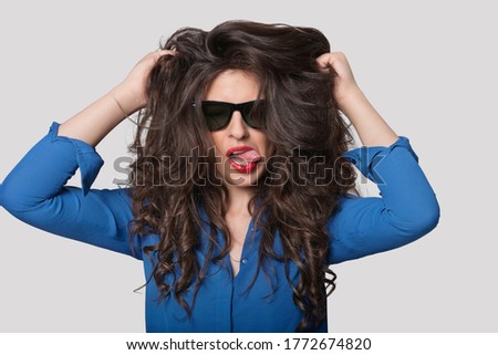 Portrait of a flirtatious young woman over gray background
