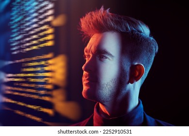 Portrait of a focused confident man looking at the screen hologram. Cyber theme. IT, developmant, programming.