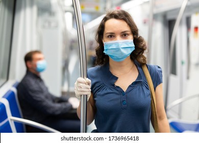 Portrait Of Focused Woman In Disposable Mask And Gloves Traveling In Subway Train During Daily Commute To Work In Spring Day. Concept Of New Life Reality And Precautions In COVID 19 Pandemic