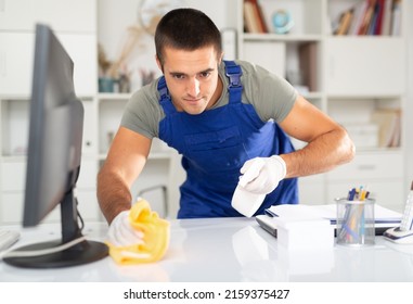 Portrait of focused worker of office cleaning service wiping desk with detergent.. - Shutterstock ID 2159375427