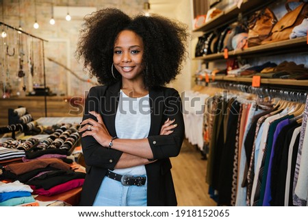 Portrait with folded arms a young beautiful owner of clothes shop at entrance of commercial activity - Millennial starts a new start-up activities in her city - Sales assistant waits for customers