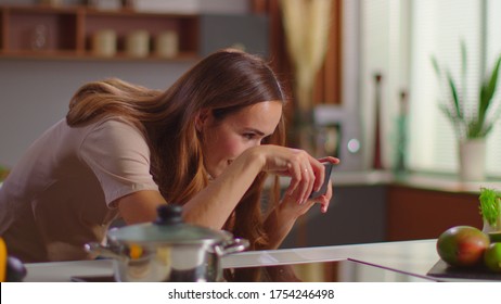 Portrait Of Food Blogger Taking Picture On Mobile Phone Of Fruits On Kitchen Table. Attractive Woman Using Smartphone Indoor In Slow Motion. Young Lady Making Fod Photo At Domestic Kitchen