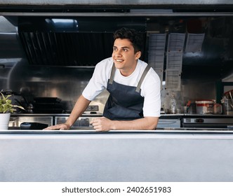 Portrait of a food truck owner. Young man working as a cook in a food truck. - Powered by Shutterstock