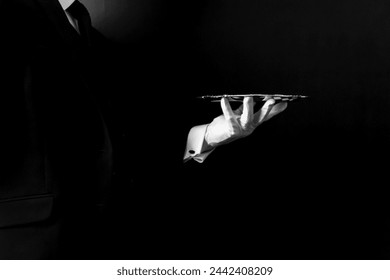 Portrait of Formal Butler or Waiter in Dark Suit and White Gloves Holding Serving Tray. Service Industry and Professional Hospitality.