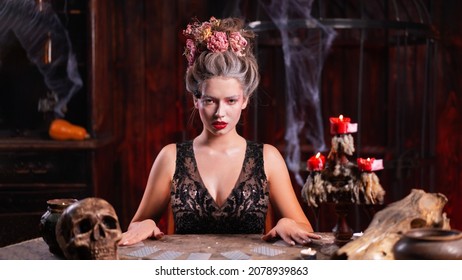 Portrait Fortune Teller Woman Reading Future On Magical Cards. Magic And Divination. Young Beautiful Enchanted Female Witch Sitting On The Table Waiting Your Desire. Scary Halloween Atmosphere