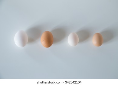 portrait of four eggs several colors and size, but are equal inside, on neutral background