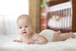 Portrait Of A Four Months Old Baby On The Bed In Nursery Room