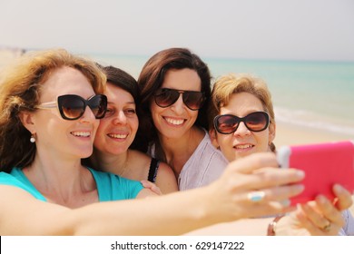 Portrait Of Four Smiling 40 Years Old Women Outdoors