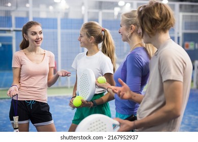 Portrait of four tennis players of different ages standing with padel rackets indoors, discussing topical issues of the ..upcoming game on the court - Powered by Shutterstock