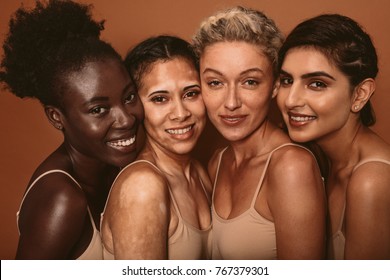 Portrait of four young women with different skin types. Diverse group of females standing together and looking at camera.