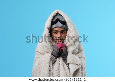 Portrait of freezing young asian man in winter