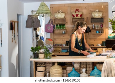 Portrait Of French Blonde Mature Woman Working Happy At Her Handmade Gifts Store In France, Entrepreneur Concept.