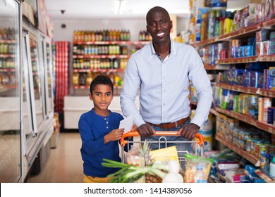 Portrait Of Friendly African American Father And Son With Purchases During Family Shopping In Store