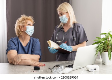 Portrait Of Friendly Caregiver Posing With Elderly Ill Woman Wearing Surgical Mask Because Of Covid-19 Pandemic