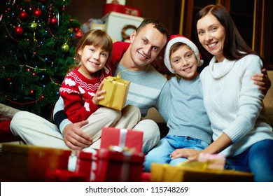 Portrait Of Friendly Family Looking At Camera On Christmas Evening