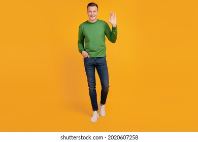 Portrait Of Friendly Neighbor Guy Walk Look Camera Wave Hand On Yellow Background