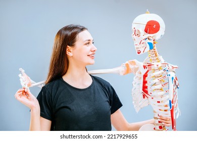 Portrait of friendly positive woman professional pilates instructor hugging with v equipment at gym of rehabilitation center. Active and healthy life rehabilitation concept