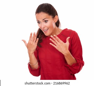 Portrait of friendly young lady on red shirt with surprised gesture smiling and looking down on isolated studio