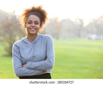 Portrait of a friendly young woman standing outside 