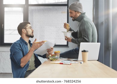 Portrait of friends or business partners discuss together new startup, have lunch break, sit over office interior, busy creating future project, drink hot coffee. People, nurtrition, healthy dinner