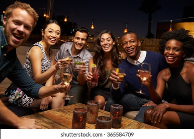 Portrait Of Friends Enjoying Night Out At Rooftop Bar
