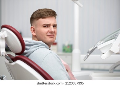 Portrait of frighten scared suffering patient, young handsome man is lying, having a seat in medical chair in dental office before or after treatment in clinic. Dentistry, stomatology phobia, fear - Powered by Shutterstock