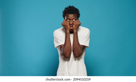 Portrait Of Frightened Man Having Hands On Mouth. Scared Person Feeling Anxious And Panicked In Studio While Looking At Horror Scene And Scary Movie. Afraid Adult Having Terrified Reaction