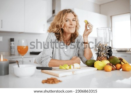 Photo of Portrait, fruit salad and apple with a senior woman in the kitchen of her home for health, diet or nutrition. Smile, food and cooking with a happy mature female pension eating healthy in the house