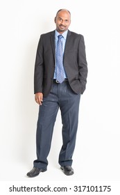 Portrait Of Full Body Mature Indian Business Man Arms Crossed, Standing On Plain Background.