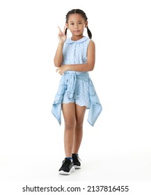 Portrait full body studio cutout shot of Asian young happy cheerful pigtail braid hairstyle elementary school girl in blue sleeveless dress standing posing smiling look at camera on white background.