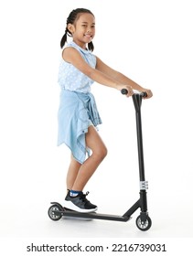 Portrait Full Body Studio Cutout Shot Of Asian Young Playful Cheerful Pigtail Braid Hair Girl Model In Blue Sleeveless Dress Standing Posing Riding Scooter Smiling Look At Camera On White Background.