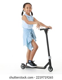 Portrait Full Body Studio Cutout Shot Of Asian Young Playful Cheerful Pigtail Braid Hair Girl Model In Blue Sleeveless Dress Standing Posing Riding Scooter Smiling Look At Camera On White Background.