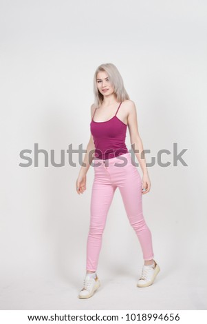 portrait in full growth of a beautiful young attractive woman with white hair dressed in a pink t-shirt and jeans isolated on a white background.