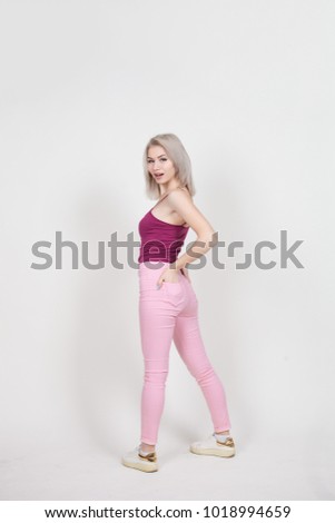 portrait in full growth of a beautiful young attractive woman with white hair dressed in a pink t-shirt and jeans isolated on a white background.