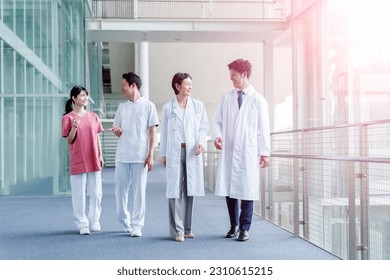 portrait of a full length asian medical team in doctor coat and scrub in a hospital - Powered by Shutterstock