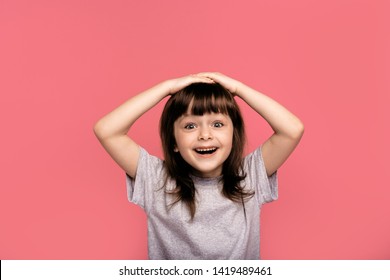 Portrait Of Funky Cute Astonished Surprised Child Kid Little Girl Touch Hand Head Shout Yell Wonder Hear Incredible Information Bargain Impressed Dressed Grey Clothing Isolated Pink Background