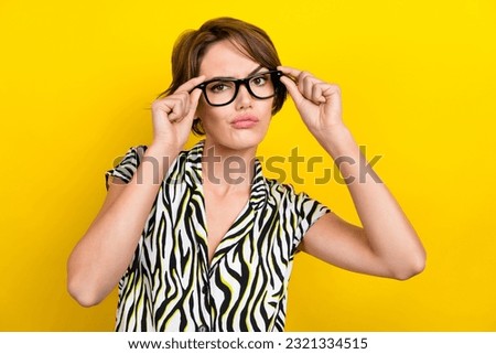 Portrait of funky gorgeous woman with short haircut wear striped blouse hands touch glasses cool look isolated on yellow color background
