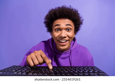 Portrait of funky optimistic person wear violet hoodie typing meesage on keyboard look at display isolated on purple color background - Shutterstock ID 2314619261